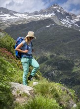 Hiker on hiking trail in front of mountains