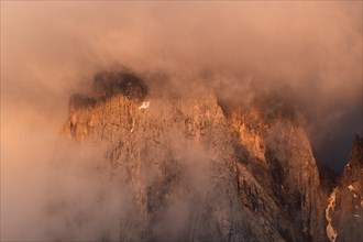 Rock face framed by clouds at sunset