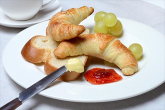 Croissants and slice of butter plait on plate