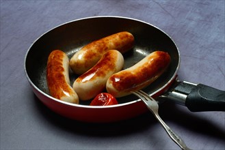 Chipolata sausages in pan
