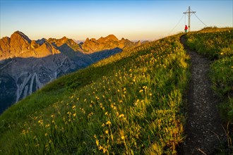 Small mountain trail with mountaineer and summit of the Uentschenspitze at sunrise