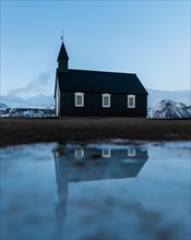 Black small church with reflection