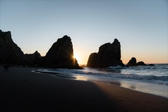 Marked rocks at Praia da Ursa beach at sunset