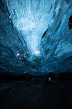 Person in an ice cave with headlamp