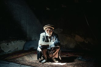 Man sitting on a carpet in his house