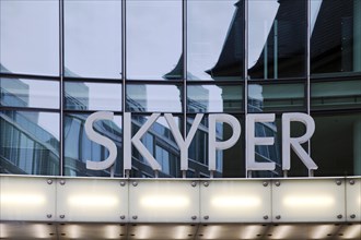 Skyper lettering in front of glass facade
