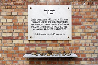 Memorial plaque commemorating the liberation of the Jewish ghetto on a wall of red bricks