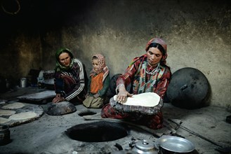 Two woman and a child baking flat bread