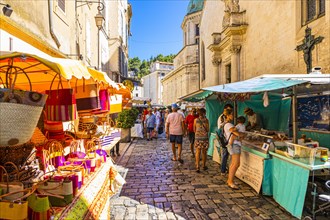 Tourists strolling through the stalls at the weekly market market in Apt