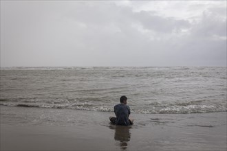 Bather on the beach from Cox's Bazaar to monsoon rain