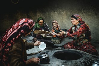 Three woman and a child baking flat bread