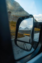 View of the fjord landscape through Campervan side mirror