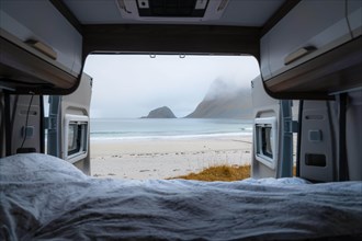 View from the rear of the campervan to beach with turquoise water