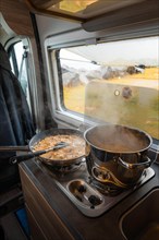 Spaghetti with creamy cream sauce cooked on gas stove in Campervan