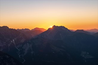 Last sunrays at sunset behind mountain silhouette