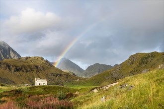 Chapel with rainbow in the mountains of Lofoten