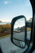 View of the fjord landscape through Campervan side mirror