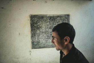 Youth in front of a blackboard in a classroom