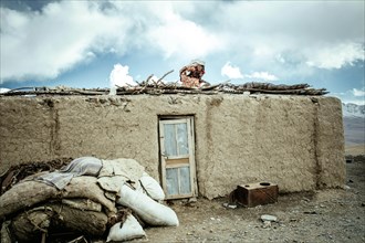 Woman on the roof of a mud house