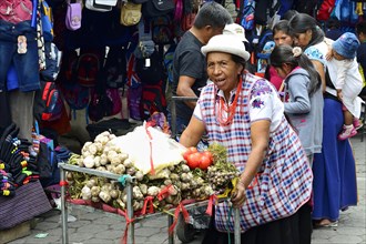 Woman pushing a trolley with garlic at the market