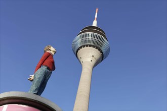 Realistic female figure on an advertising pillar in front of the Rhine Tower