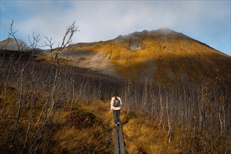 Woman hiking to Sega mountain in autumnal fjord landscape