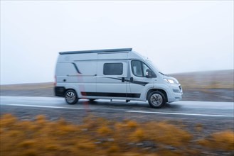 Campervan in fast drive on a road near the North Cape