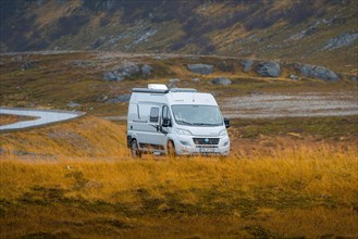 Campervan parked on grassed parking lot near Kafjord