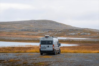 Campervan with rear view stands on parking lot near Kafjord