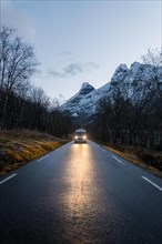 Campervan with bright lights on road near Trollstigen