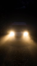 Campervan with bright lights standing in the fog