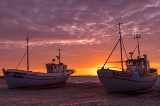 Fishing boats on the beach at sunset