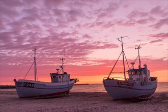 Fishing boats on the beach at sunset
