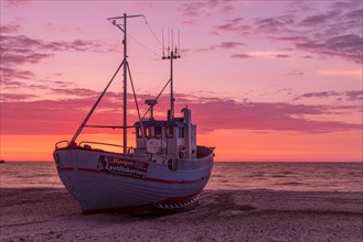 Fishing boat on the beach at sunset