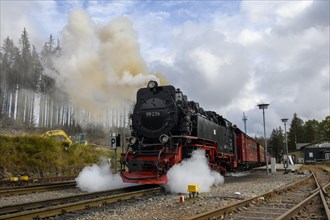 Smoking steam locomotive emits steam sideways