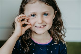 Girl with tooth gap and tooth in hand