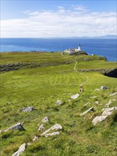 Hiking trail to the lighthouse on the Neist Point peninsula with views of the Outer Hebrides on the horizon