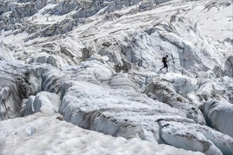 Climber walking on rutted glacier
