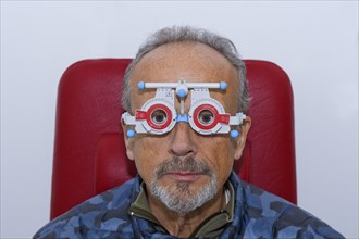 Male person during eye measurement with measuring glasses