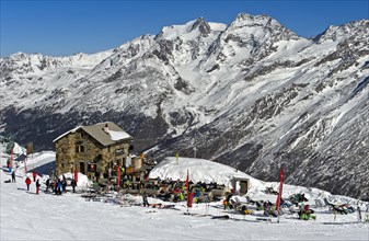 Laengfluee hut and skiers in the snowy Swiss Alps