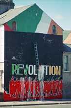 Revolution lettering on a house front is being repaired