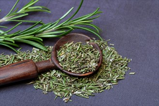 Dried and crushed rosemary in wooden spoon