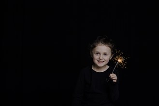 Girl with star thrower in front of dark background