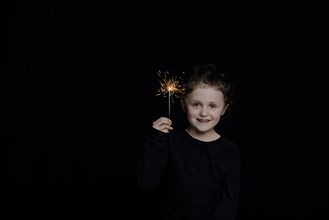 Girl with star thrower in front of dark background