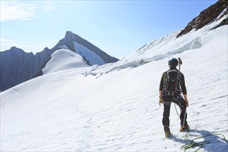 Mountaineer on a high climb on a long rope over a snowfield on the Altmann