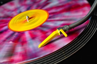Colorful vinyl on a turntable with yellow pickup