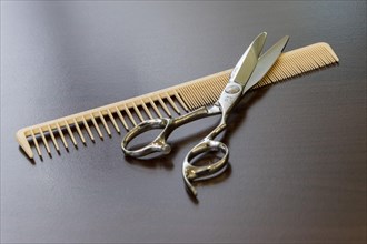 Scissors and comb lie on a table