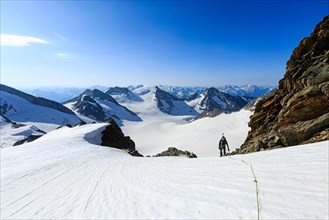 Mountaineer on a high climb on a long rope over a snowfield on the Altmann