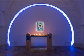 Colourfully illuminated vestibule with offering candles