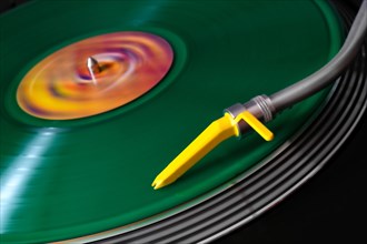 Green vinyl on a record player with yellow pickup